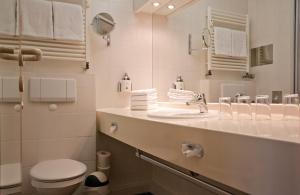 ein weißes Bad mit einem Waschbecken und einem WC in der Unterkunft Inselresidenz Strandburg Juist - Wohnung 106 (Ref. 50958) in Juist