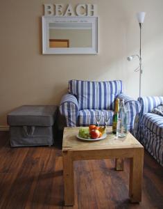 ein Wohnzimmer mit einem Sofa und einem Tisch mit einem Obstteller in der Unterkunft Inselresidenz Strandburg Juist - Wohnung 106 (Ref. 50958) in Juist