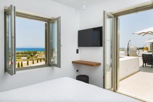 a bedroom with a bed and a view of the ocean at Golden Bay luxury villas and suites in Chrissi Akti