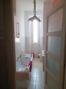 a bathroom with a tub and a toilet and a window at Casa GIULIVA in Alessandria