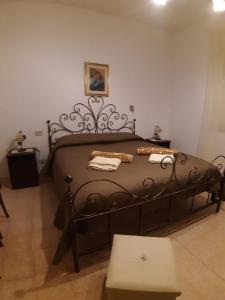 a bedroom with a black bed with towels on it at Villa Guido in Regalbuto