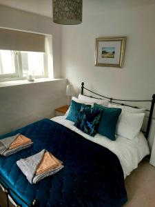 ein Schlafzimmer mit einem großen Bett mit blauer Bettwäsche und Kissen in der Unterkunft York House in Conwy