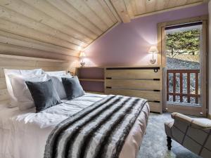 a bedroom with a large bed and a window at Chalet Méribel, 5 pièces, 11 personnes - FR-1-565-46 in Les Allues