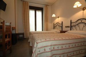 マドリードにあるオスタル イヴォルのベッド2台と窓が備わるホテルルームです。