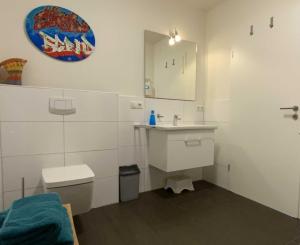 uma casa de banho com um lavatório, um WC e um espelho. em Quartier Hohe Geest 8 - a69853 em Cuxhaven