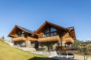 a large wooden house with a mountain at Ferienlodge Edelstein in Forstau