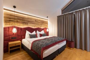 a bedroom with a large bed with a red headboard at Ferienlodge Edelstein in Forstau