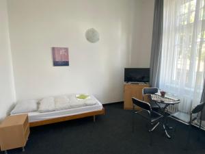 1 dormitorio con 1 cama, mesa y sillas en Penzion Zahrada Čech, en Litoměřice