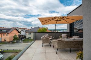 patio z parasolem i krzesłami na balkonie w obiekcie Apartments Villa Popp w Lublanie