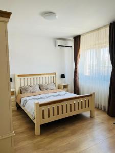 a bedroom with a large bed and a window at Dante Residence in Alba Iulia