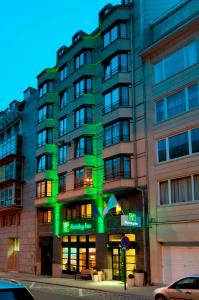 a building with green lights on the side of it at Holiday Inn Brussels Schuman, an IHG Hotel in Brussels