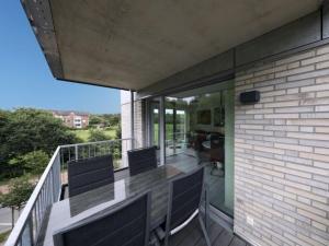 een balkon met een tafel en stoelen erop bij Quartier Hohe Geest 15 - Nordseebrise - a69852 in Cuxhaven