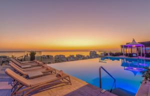 a pool with lounge chairs on the roof of a building at AX The Palace in Sliema