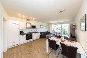 uma cozinha e sala de estar com mesa e cadeiras em Quartier Hohe Geest 16 - Lena - a69851 em Cuxhaven