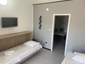 um quarto com uma cama, uma mesa e uma televisão em Apartments Villa Jelena em Vodice