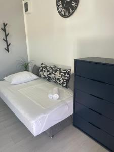 um quarto com uma cama e um relógio na parede em Apartments Villa Jelena em Vodice