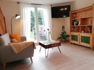 ein Wohnzimmer mit einem Sofa und einem Tisch in der Unterkunft Käthes Sommerhaus in Schöna