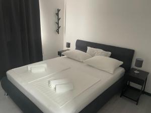 uma cama branca com duas toalhas brancas em Apartments Villa Jelena em Vodice