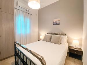 sypialnia z białym łóżkiem i oknem w obiekcie Olivar Holiday House w mieście Alikes