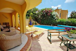 een patio met een zwembad en stoelen en een tafel bij Nieto - holiday home with private swimming pool in Benitachell in Benitachell