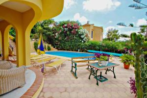 een patio met een tafel en stoelen en een zwembad bij Nieto - holiday home with private swimming pool in Benitachell in Benitachell