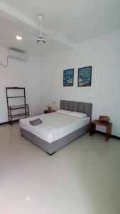 a bedroom with a large bed and a chair at Green Hill Mirissa in Mirissa
