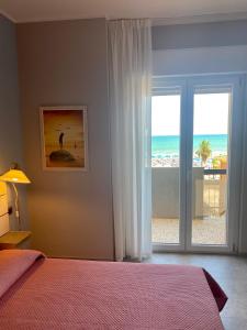 1 dormitorio con cama y vistas a la playa en Oltremare Rooms, en Vasto