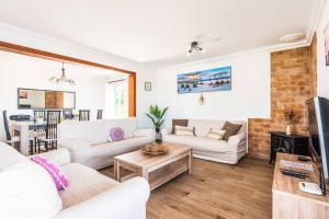 a living room with white couches and a fireplace at Villa Pepita in Binibeca