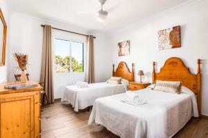 a bedroom with two beds and a window at Villa Pepita in Binibeca +38 photos