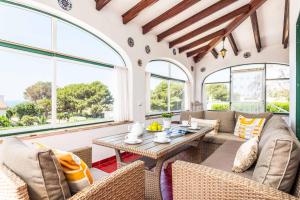 a living room with a table and chairs and windows at Villa Pepita in Binibeca