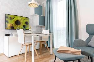 een woonkamer met een tafel en stoelen en een bureau bij NINO-Boardinghouse 26 - a69886 in Nordhorn