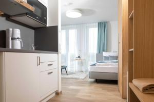 Habitación con 1 dormitorio con 1 cama y cocina en NINO-Boardinghouse 26 - a69886, en Nordhorn