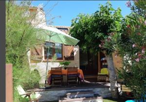 une maison avec une table et des chaises dans une cour dans l'établissement 70 M2 Maison Moderne 3 étoiles TARIFS 2026, à Saint Pierre La Mer