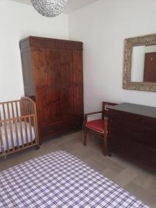 een slaapkamer met een wieg, een dressoir en een spiegel bij CASA SIMONE in Porto San Giorgio