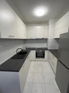 ザグレブにあるApartman Antonのキッチン(白いキャビネット、黒いカウンタートップ付) +12枚の写真