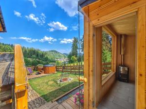 a wooden house with a balcony with a view of a yard at LK Resort Łapsze domy z prywatną balią i sauną in Łapsze Niżne