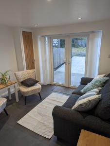 a living room with a couch and a chair at Coach House Cottage in Runswick