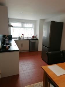 a large kitchen with a refrigerator and a table at Coach House Cottage in Runswick