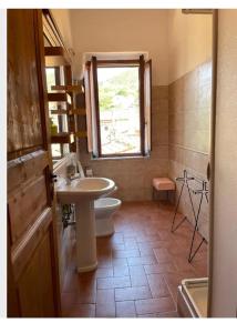 スカルリーノにあるAppartamento Felixのバスルーム(洗面台、トイレ付)、窓が備わります。