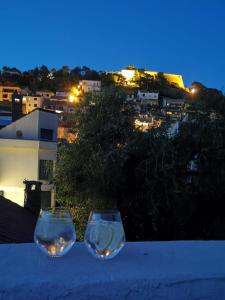 two wine glasses sitting on top of a table at night at APP Old Garden House in Šibenik