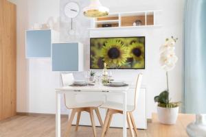 een witte eetkamer met een witte tafel en stoelen bij NINO-Boardinghouse 8 - a69899 in Nordhorn