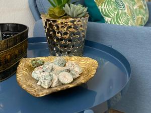 eine Platte mit Steinen auf einem Tisch mit einer Vase in der Unterkunft Sarahs Kite Vivienda Vacacional en Playa del Burrero in Playa del Burrero
