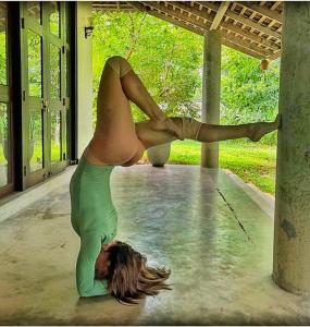 a woman doing a yoga pose in the water at Villa Greenary in Unawatuna