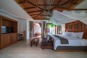 - une chambre avec un grand lit et une télévision dans l'établissement Malisa Villa Suites - SHA Extra Plus, à Kata Beach