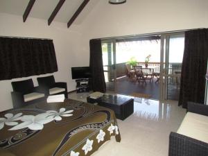 a bedroom with a bed and a living room at Muri Shores in Rarotonga