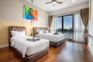 a bedroom with two beds and a large window at AJ Suites @ Loft Imago KK in Kota Kinabalu