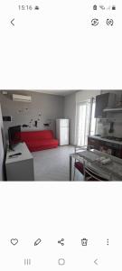 Habitación con cama roja y mesa. en Appartamento al primo piano MARGHERITA, en Sabaudia