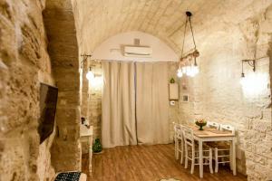 ein Esszimmer mit einem Tisch in einer Steinmauer in der Unterkunft Nicola's House Luxury Loft in Bari