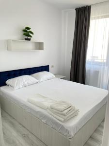 ママイア・ノルドにあるAquazure Studio Residenceのベッド(白いシーツ、タオル付)