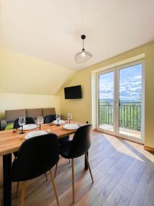 a dining room with a table and chairs and a couch at Apartament Ptasi Śpiew in Rabka-Zdrój